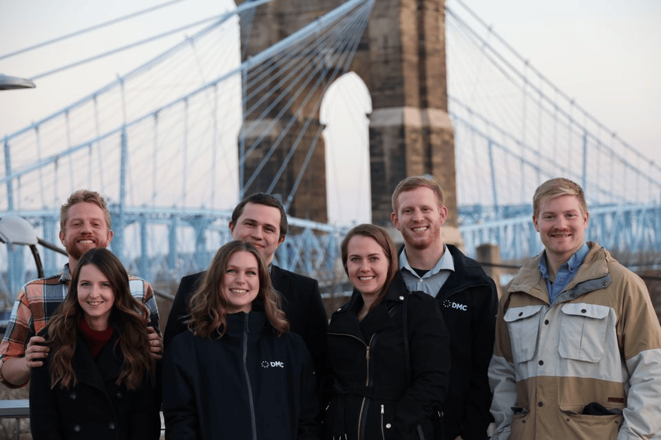DMC's Cincinnati team poses for a photo outdoors.
