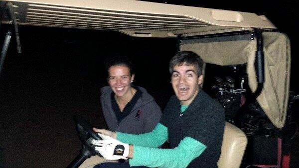 Two engineers take a ride in a golf cart.