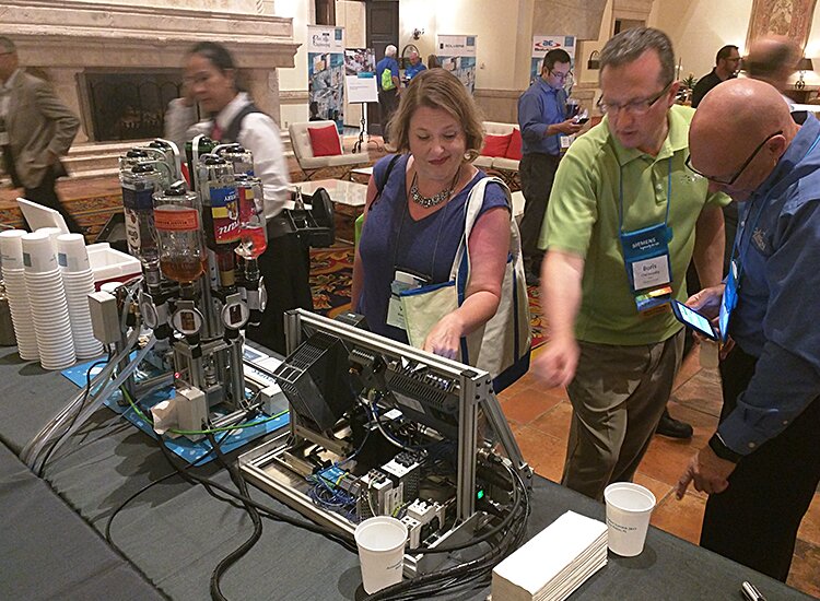 Picture of Boris Cherkasskiy demonstrating the Siemens Drink Bot.