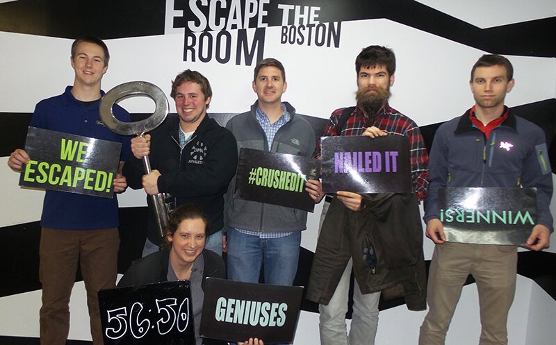 DMC Boston's team after escaping the room with lots of fun signs and props