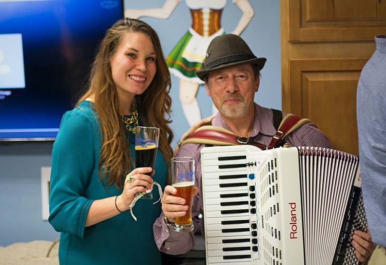 Marketing Coordinator, Jessica, poses with the accordian player at the DMC Boston office.
