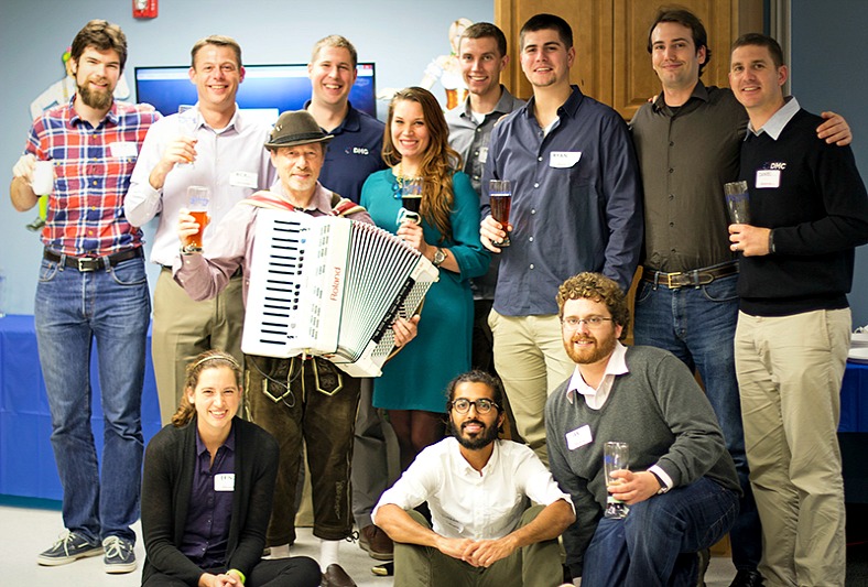 All DMC employees pose with the accordian player for a picture.
