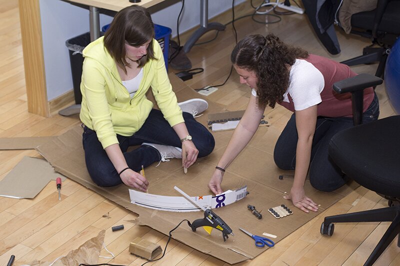 Katherine and Erin building a Maglev train out of cardboard.