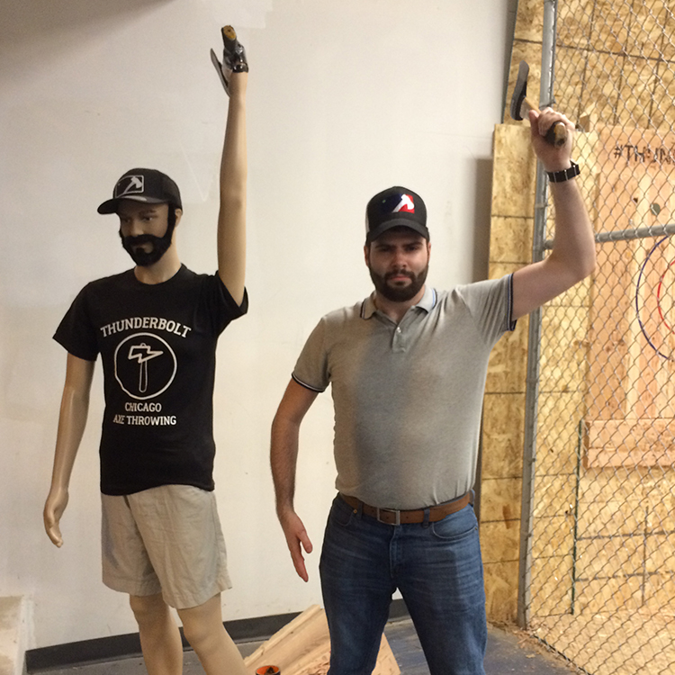 Patrick Smith mirroring a mannequin holding an axe.