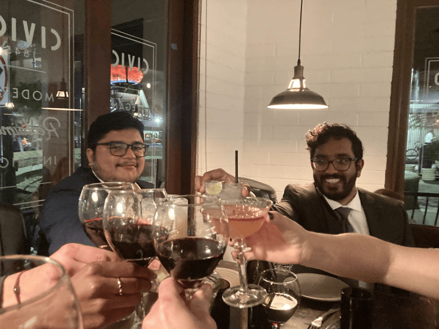 Two people toast wine glasses in a restaurant.