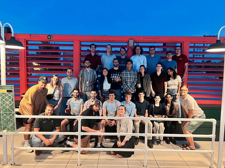 DMC gathers for a group photo on a roof deck.