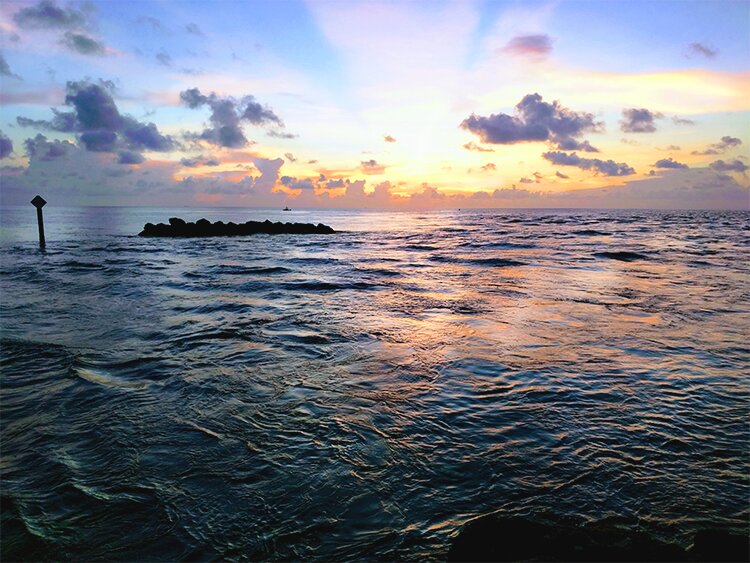 Photo of the sun hitting the ocean.