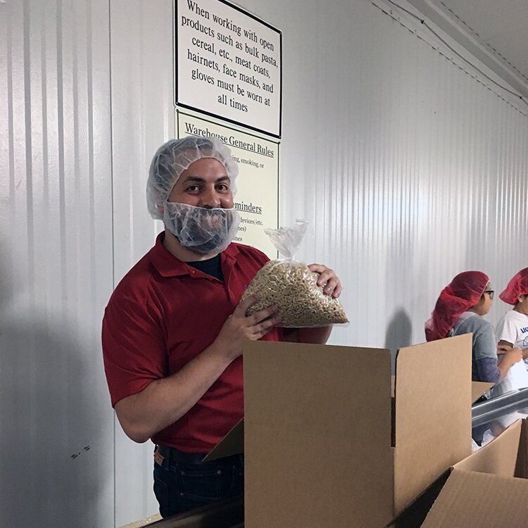 Tim Herrmann of DMC boxing pasta for Chicago Food Depository.