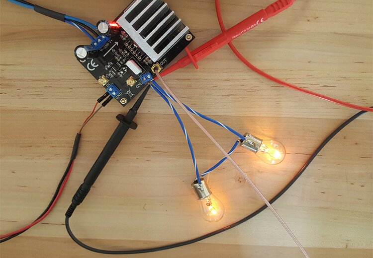 Two 12v automotive light bulbs in series to act as a load connect differential Oscilloscope probes