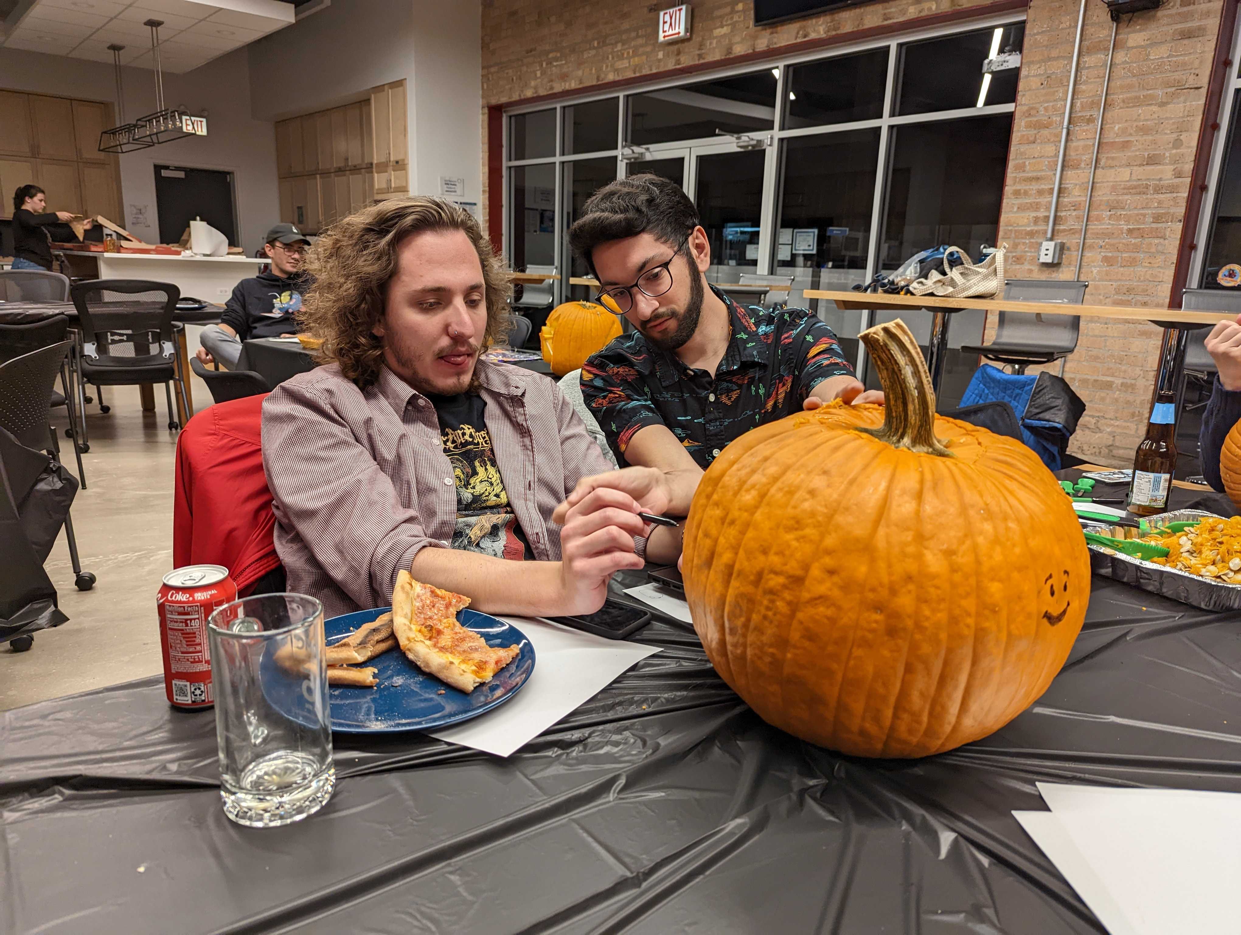 Two people carving a pumpkin.