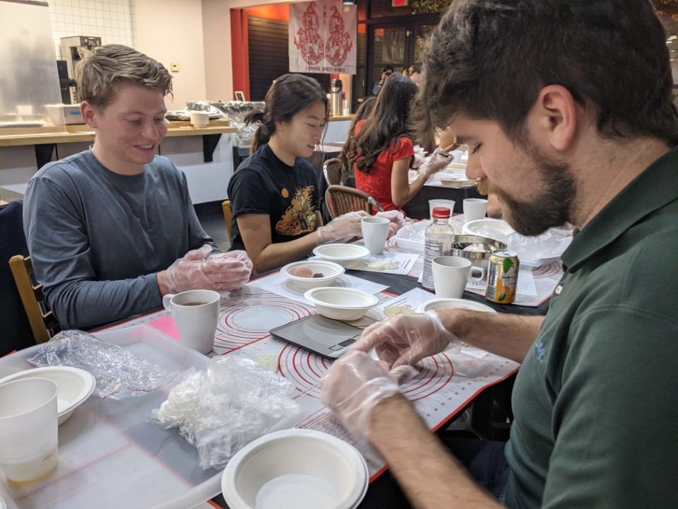 A group of people make moon cakes at a restaurant.