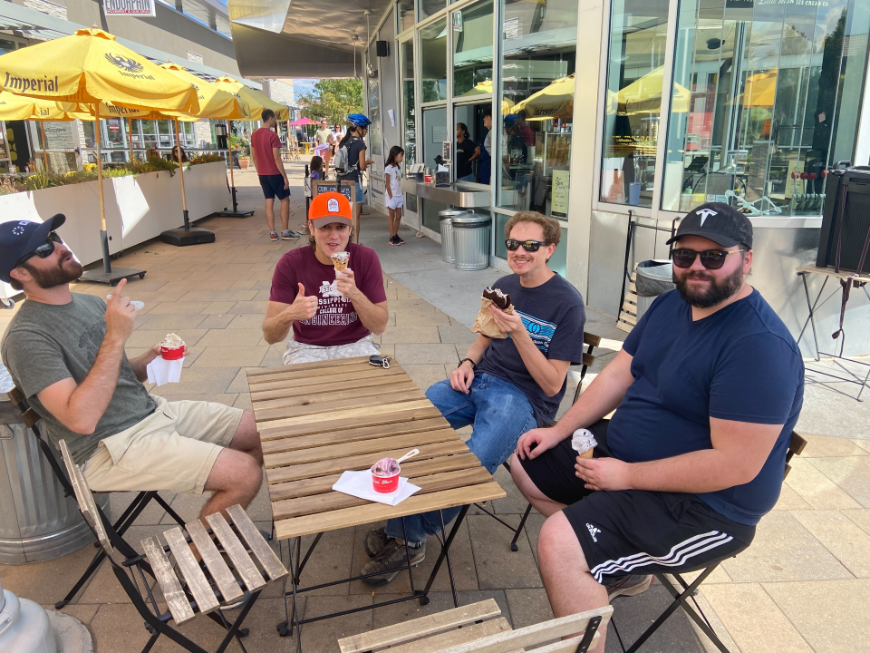 A group of people eating ice cream on a patio.