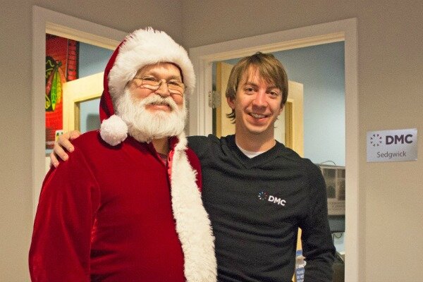 DMC engineer, Alex, smiles with Santa.