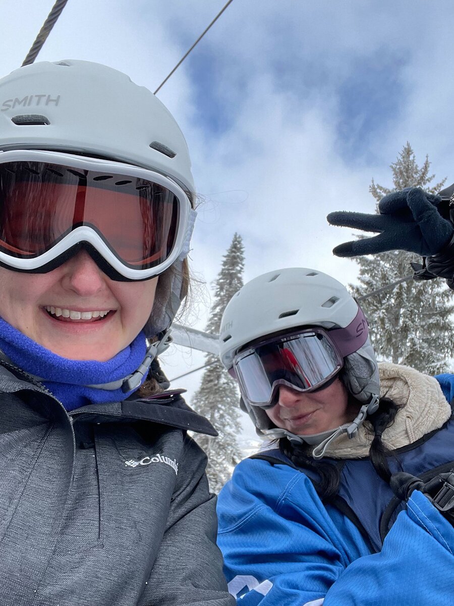 Two people in ski attire pose for a selfie.