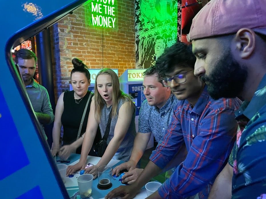A group of people playing an arcade game