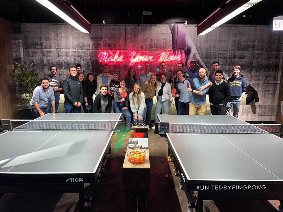 a group photo at a ping pong table.