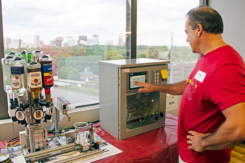 A guest at DMC St. Louis' Grand Opening uses the DrinkBot